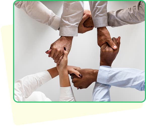 A man holding dollars and a laptop smiling with a green background