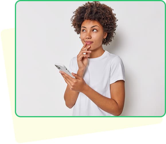 A man holding dollars and a laptop smiling with a green background